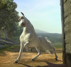 a large white dog standing on top of a dirt field next to a stone wall