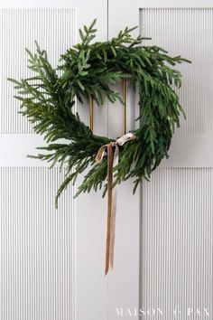 a green wreath hanging on the front door