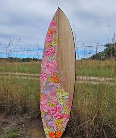 a wooden surfboard with flowers painted on it