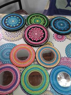 colorful plates are arranged on a table with mirrors in the middle and one is decorated with beads