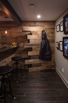 there is a coat hanging up on the wall next to two stools in this room