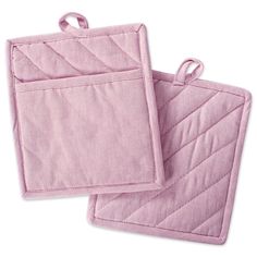 two pink oven mitts sitting next to each other