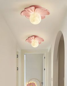 the hallway is decorated in pink and white with flowers on the ceiling, along with two circular lights