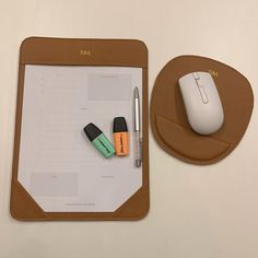 a clipboard with a pen, mouse and other items on it next to a computer mouse pad