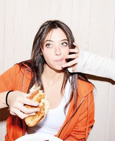 a woman holding a sandwich in front of her face