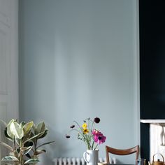 two vases filled with flowers sitting on top of a table next to a radiator