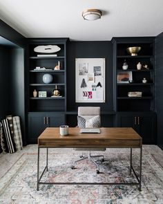 a living room with black bookcases and a coffee table in front of it