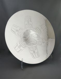 a white plate sitting on top of a black table next to a metal stand with an airplane drawn on it