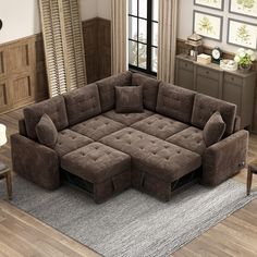 a living room with a large brown couch and matching ottomans on the floor, in front of a window