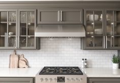 a stove top oven sitting inside of a kitchen next to cupboards and counter tops