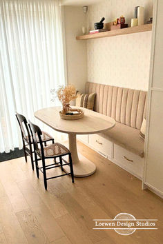 a dining table with four chairs and a bench in front of a white curtained window