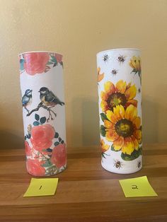 two vases sitting on top of a wooden table next to yellow post it notes