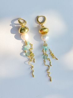 🌟 Make a statement with our unique handmade Jellyfish Earrings, designed to capture the beauty of nature. 🌟 🌊 Meticulously crafted by hand, these earrings feature high-quality brass and huggie hoop closures. Adorned with real pearls and natural fluorite stones, they add a touch of oceanic charm to any outfit. ✨ Measuring 9 cm in length and 1.3 cm in width, these earrings are perfectly sized to complement any face shape. ⚖️ Weighing 14.5 grams per pair, they are comfortable to wear all day lon Whimsical Brass Dangle Earrings, Whimsical Gold Wire Wrapped Earrings, Handmade Whimsical Brass Earrings, Handmade Ocean-inspired Gold Earrings, Nature-inspired Gold Wire Wrapped Earrings, Jelly Fish Earrings, Whimsical Gold Jewelry For Summer, Handmade Jellyfish, Jellyfish Earrings