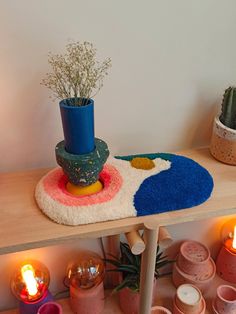 a shelf with various pots and plants on it, including a potted plant next to a rug