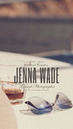 sunglasses sitting on top of a white table next to a glass with the name jennya wade