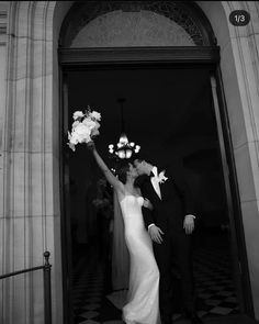 a bride and groom standing in front of a doorway