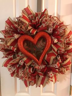 a red and white wreath with a heart on it