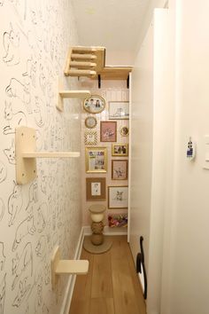 the hallway is decorated with wallpaper and pictures on the walls, as well as shelves