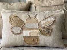 two pillows that have been made to look like a patchwork bee on the side