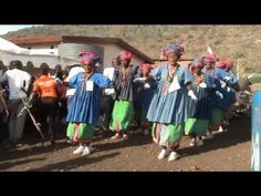 some people are standing in front of a group of people wearing colorful clothing and headgear