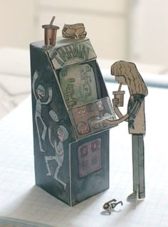 a paper model of a man playing an old school video game with a woman standing next to it