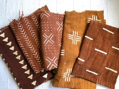 four pieces of cloth with white and brown designs on them, sitting next to each other