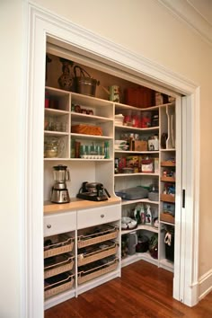 an open pantry with lots of items on the shelves and in front of it is a phone