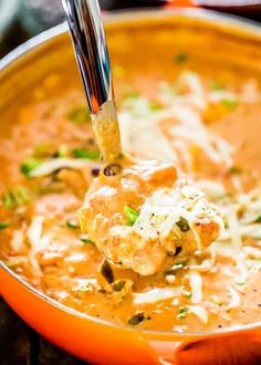 a ladle full of soup is being held up