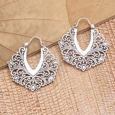 Inspired by the beauty of lush verdant leaves Suar Dwipayana in Bali designs these exquisite hoop earrings. The artisan hand crafts the earrings from sterling silver in a combination finish fashioning tendrils of precious metal that curl around a polished v-shape. Ornate Handmade Hoop Earrings, Handmade Ornate Hoop Earrings, Silver Handmade Hoop Earrings For Wedding, Bohemian Sterling Silver Hoop Earrings For Weddings, Silver Bohemian Hoop Earrings For Wedding, Bohemian Silver Hoop Earrings For Wedding, Ornate Silver Hoop Jewelry, Silver Small Hoop Jewelry For Festivals, Sterling Silver Hoop Jewelry With Intricate Design