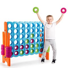 a young boy is holding two large toy discs in front of an interactive game board