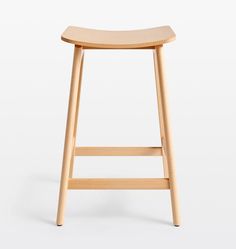 the stool is made from wood and has a curved seat on one side, and an angled