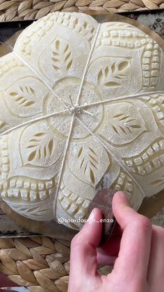 someone is carving a decorative object out of clay