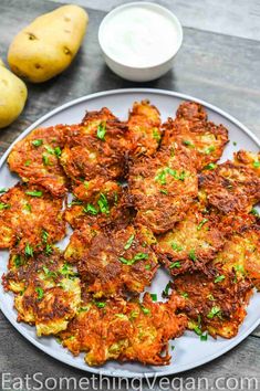 potato fritters on a plate next to potatoes