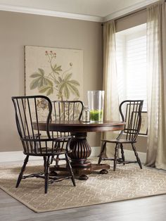 a dining room table and chairs with a rug on the floor in front of it