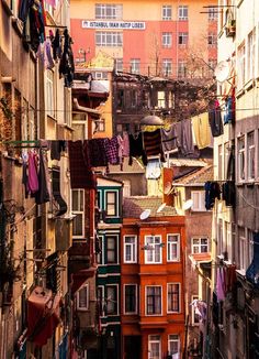 an alley way with clothes hanging out to dry on the line and buildings in the background