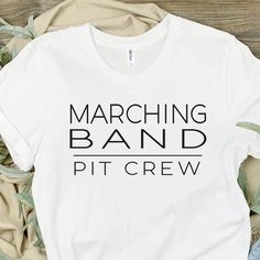 Marching Band, Pit Crew, With the band t-shirt, band shirts, high school marching band, band pit crew, custom band shirt, marching band game It's marching band season!!  Excited to offer these cute marching band pit crew shirts.  Each shirt is custom made to order featuring the wording 'Marching Band Pit Crew'.  Each shirt is made to order in your choice of white, silver or heathered tee. Please understand, these are 100% polyester & the true white may be somewhat more translucent than desired. Color Guard Shirts, Pit Crew Shirts, Marching Band Shirts, Band Mom Shirts, Colour Guard, High School Marching Band, Band Ideas, Pit Crew