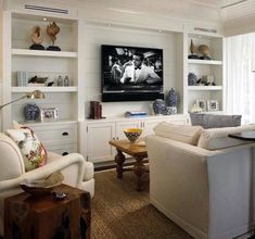 a living room filled with furniture and a flat screen tv mounted to the side of a wall