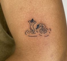 a person with a small tattoo on their arm and the image of a dog in the water