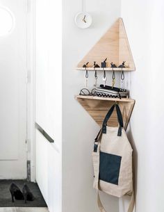 a bag hanging on the wall next to a coat rack