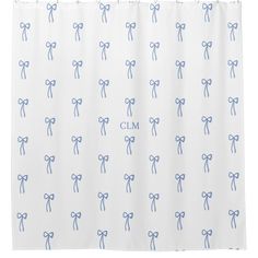 a white shower curtain with blue bows on it