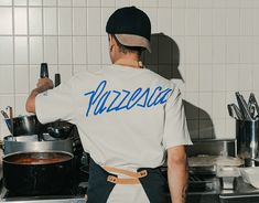 a man standing in front of a stove top oven