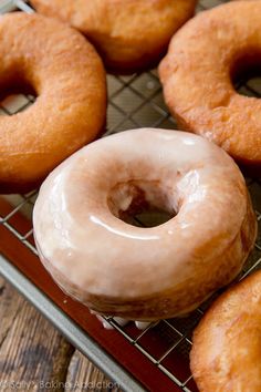 several glazed donuts sitting on a cooling rack