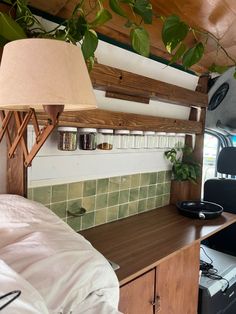 there is a lamp on the shelf above the bed in this rv with plants growing out of it