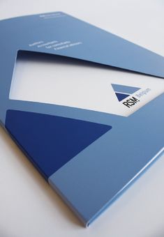 a close up of a blue and white business card on a table with an envelope