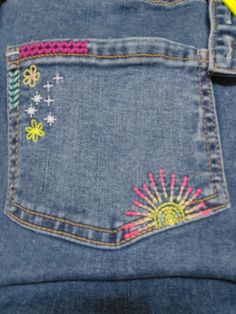 the back pocket of a pair of jeans with embroidered flowers on it and a banana