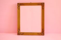 an empty wooden frame against a pink wall