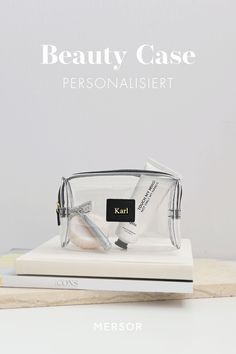 the beauty case personalisisert is on top of a white book and it's packaging