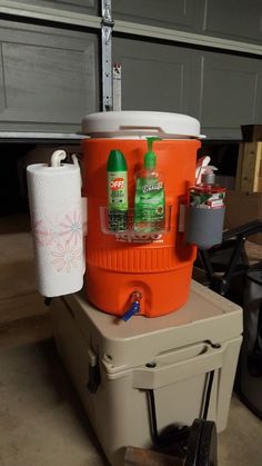 an orange cooler sitting on top of a cart