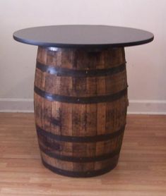 a wooden barrel table sitting on top of a hard wood floor