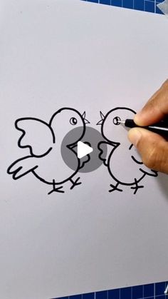 someone is drawing two birds on a piece of paper